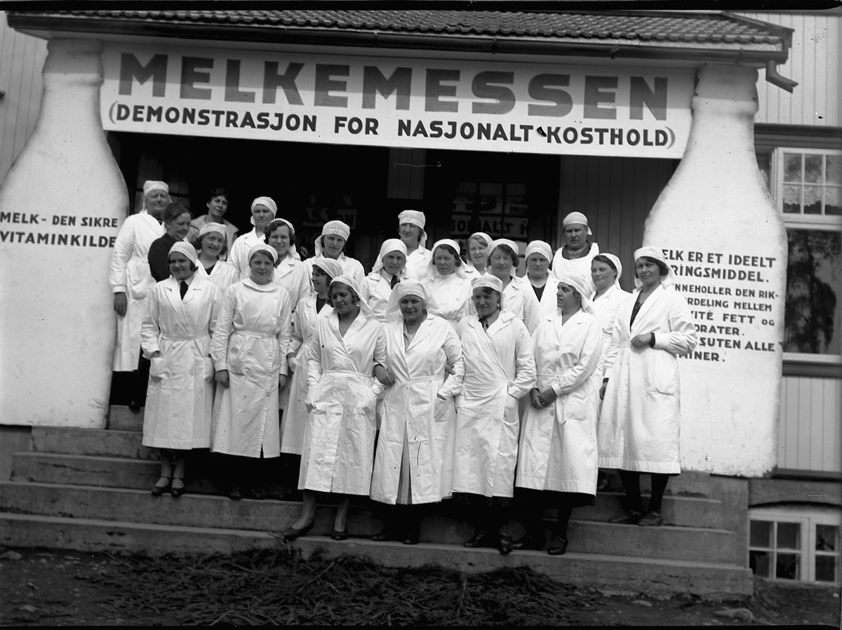 Mikkel Sveinhaug, DEN NASJONALE KOSTHOLDSMESSA, MELKEMESSEN DEMONSTRASJON FOR NASJONALT KOSTHOLD, GRUPPE UKJENTE KVINNER I HVITE FRAKKER. FOLKETS HUS MOELV.