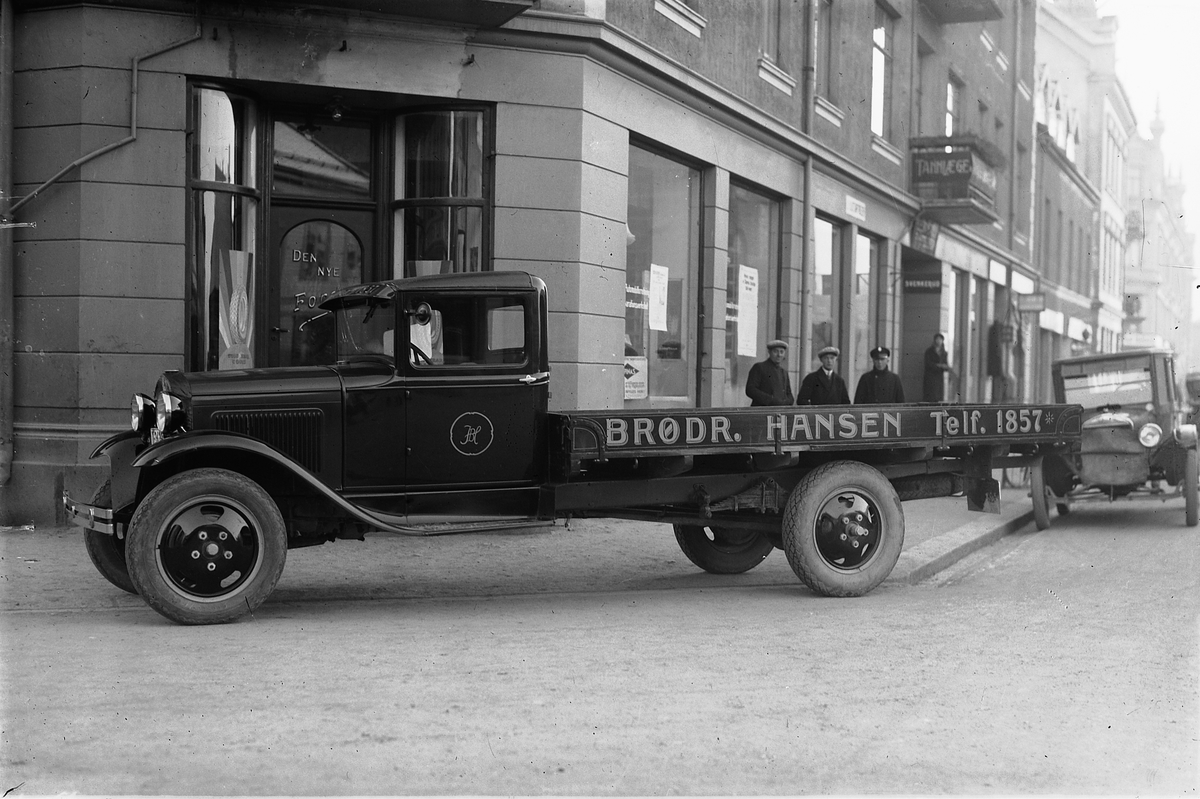 Oscar Løberg, FORD LASTEBIL (CA. 1930/31-MODELL), BAK BILEN BRØDRENE HANSEN SAMMEN MED VERKSMESTER KASPERSEN VED OPPLANDSKE AUTO (TH) i Torggata, Hamar. TIL HØYRE FORD MED VINTERTOPP (1926-MODELL).