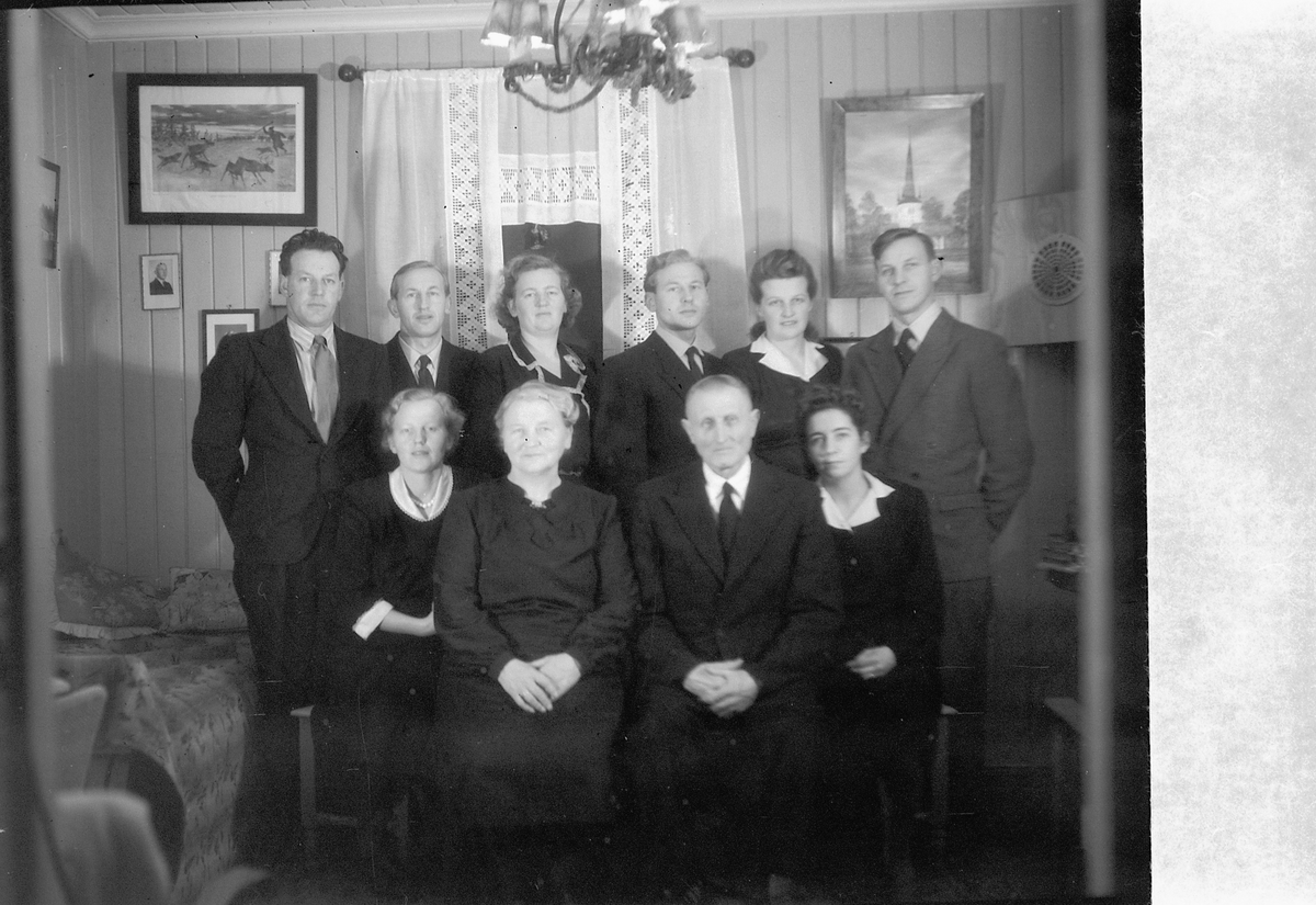 Håkon Prestkværn, Interiør. Ukjent gruppe menn og kvinner. Familiegruppe Nilssveen?