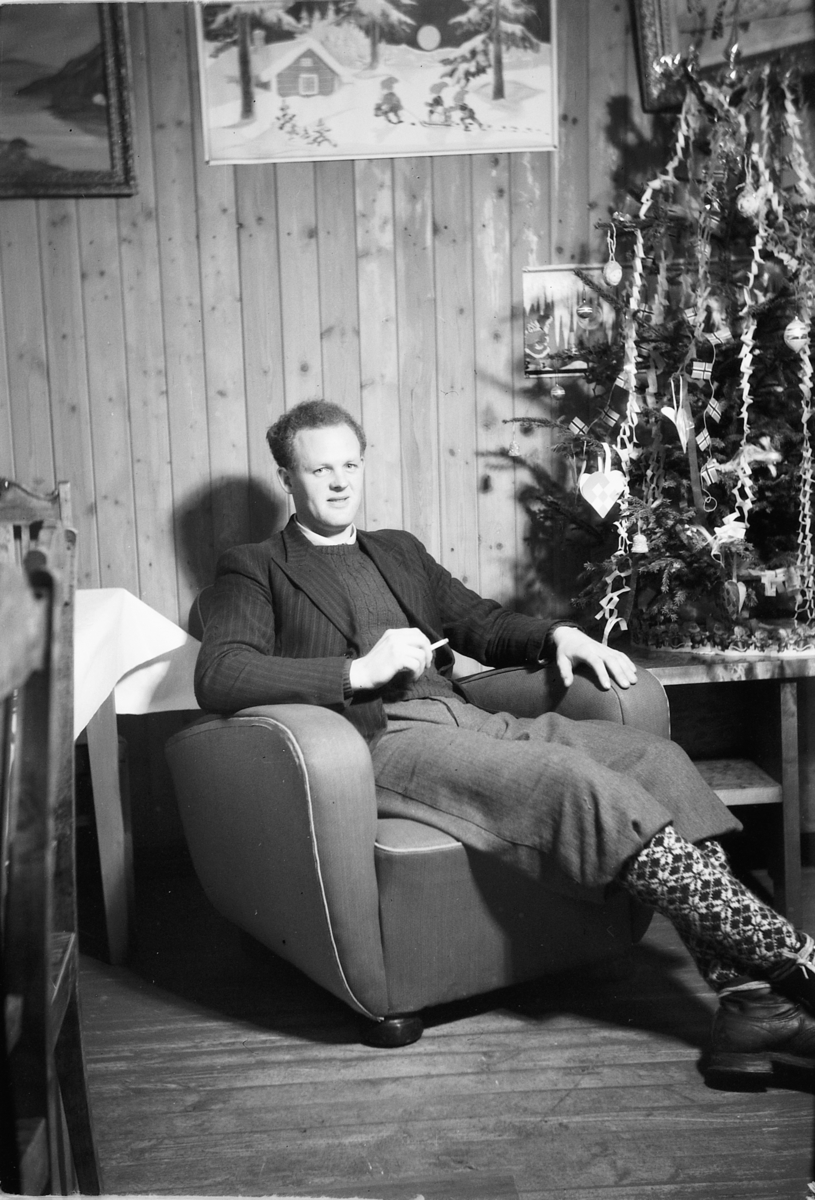 Håkon Prestkværn, Interiør, stue. Sparemøte, Syvertsen. Ukjent mann foran juletre.