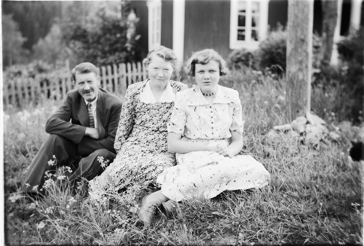 Håkon Prestkværn, Nils Haug, ukjent mann og ukjente kvinner i hagen foran et hus.
