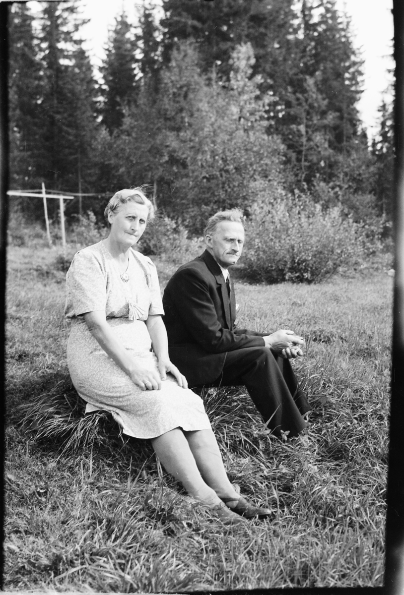 Håkon Prestkværn, Eldre kvinne og mann sitter i en hage.