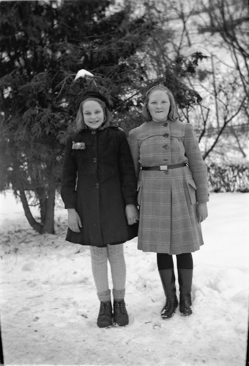 Håkon Prestkværn, To jenter ved et grantre, vinter.