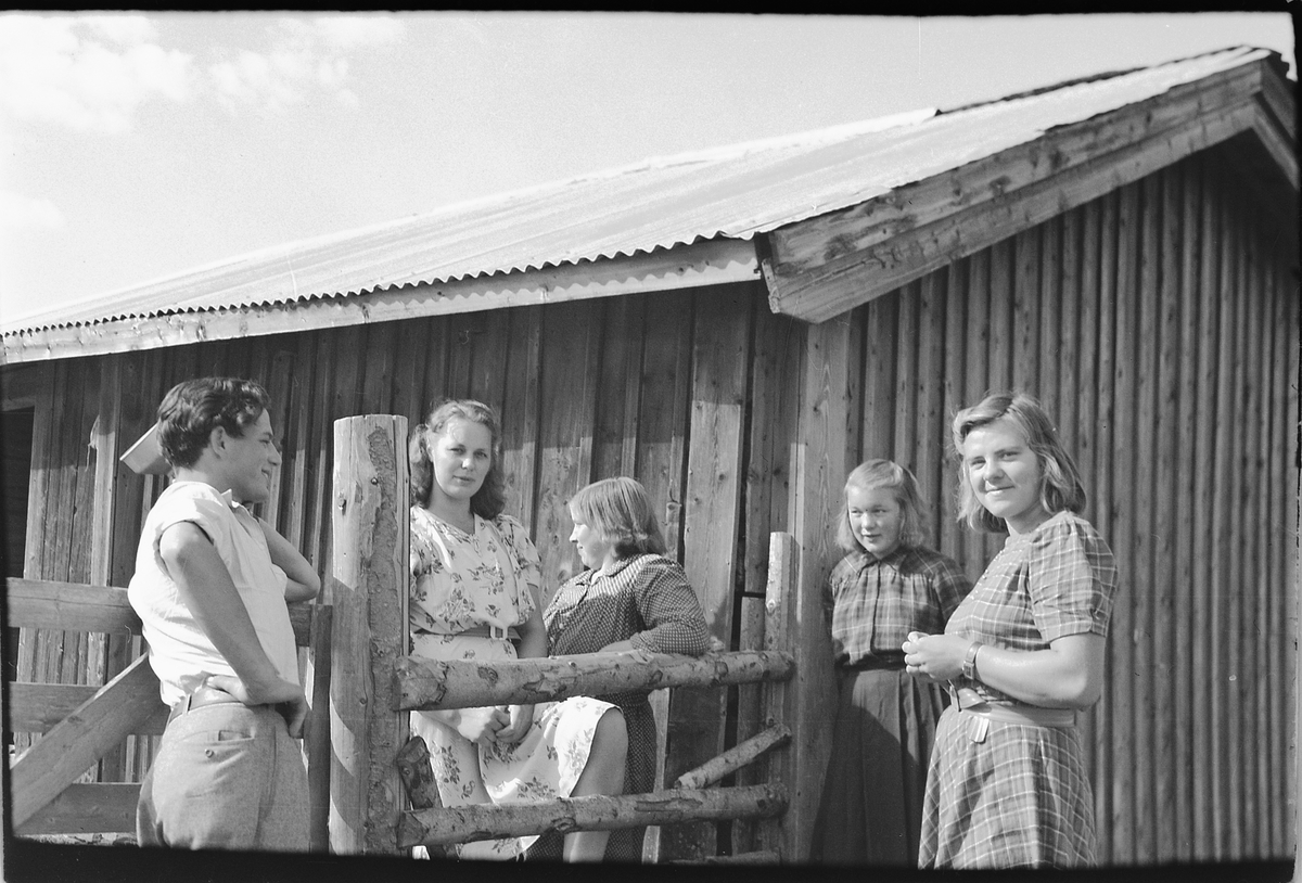 Håkon Prestkværn, Ukjent mann sammen med ukjente kvinner ved et hus med grind.
