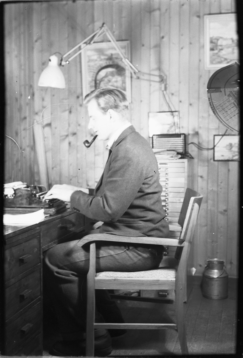 Håkon Prestkværn, Ukjent mann med pipe skriver på skrivemaskin på kontor.