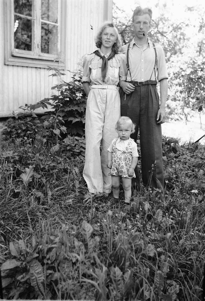 Håkon Prestkværn, Ukjent kvinne og mann med ei jente står ved et hus.