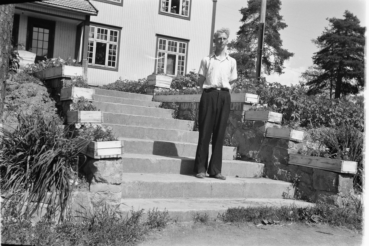 Håkon Prestkværn, Magne Antonsen står i hagetrapp, blomsterkasser.