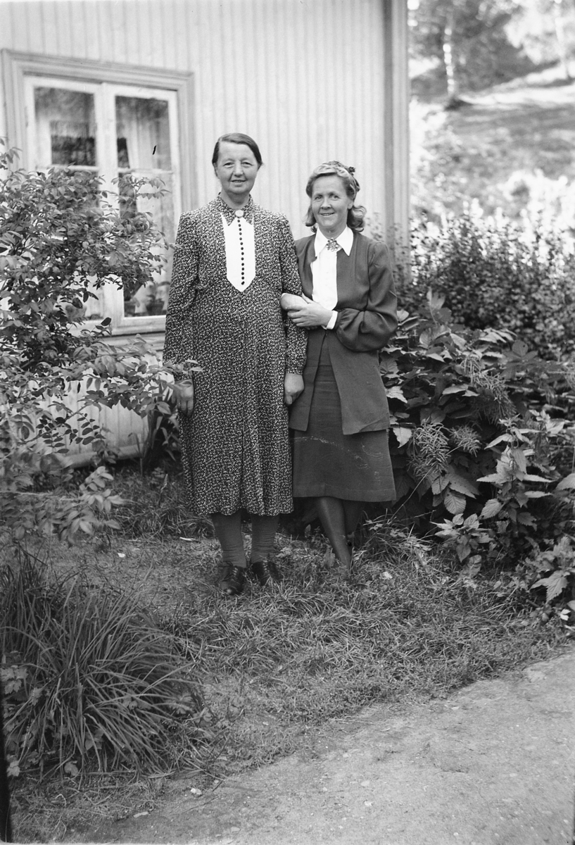 Håkon Prestkværn, To eldre kvinner ved et hus.