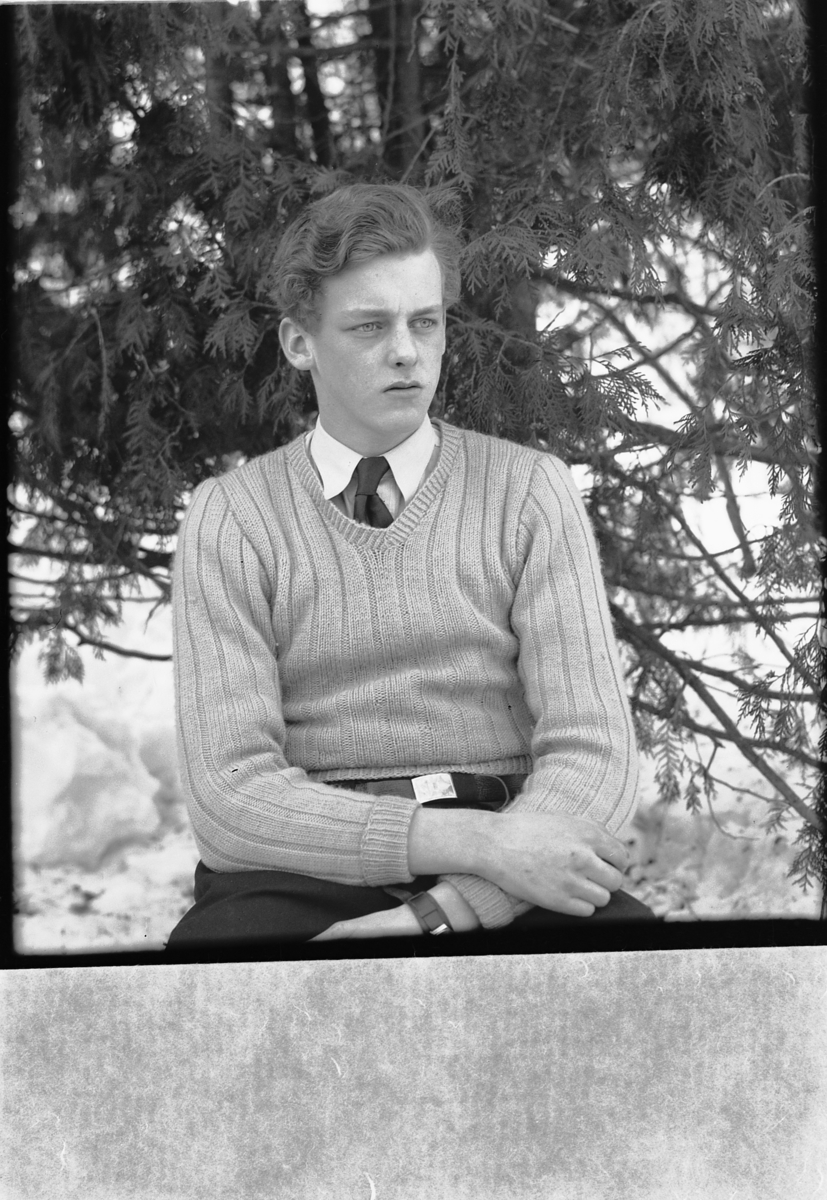 Håkon Prestkværn, Ukjent mann på en stol med et grantre i bakgrunnen.
