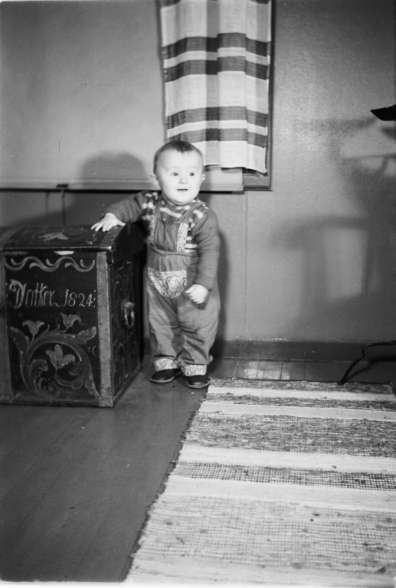 Håkon Prestkværn, Interiør, stue. Baby ved en sofa.
