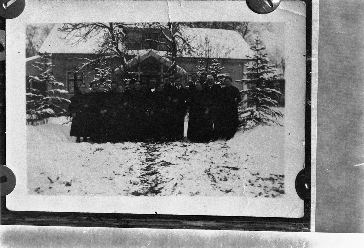 Håkon Prestkværn, Ukjent gruppe kvinner og menn samlet foran et hus.