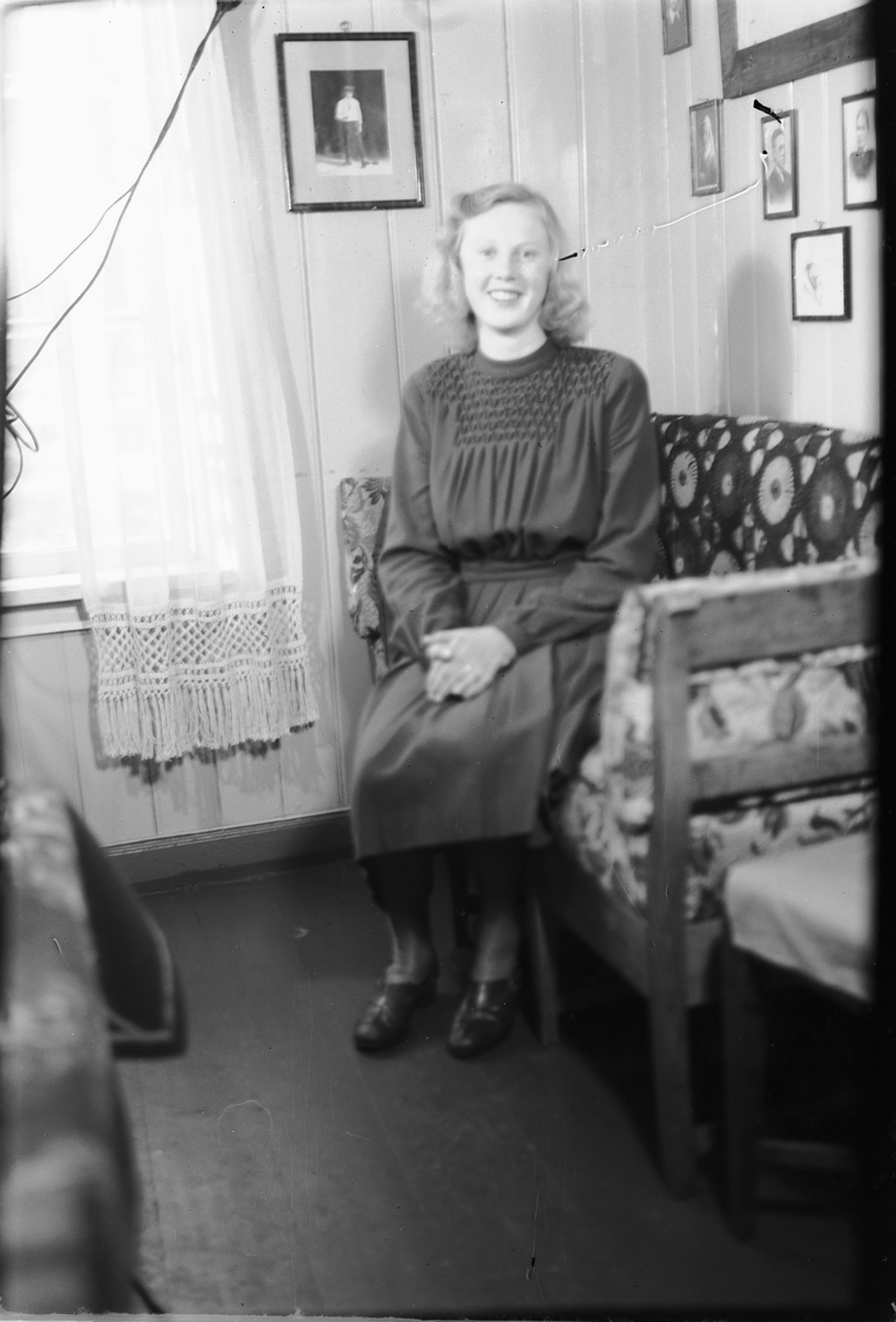 Håkon Prestkværn, Interiør, stue. Ukjent kvinne i en sofa.