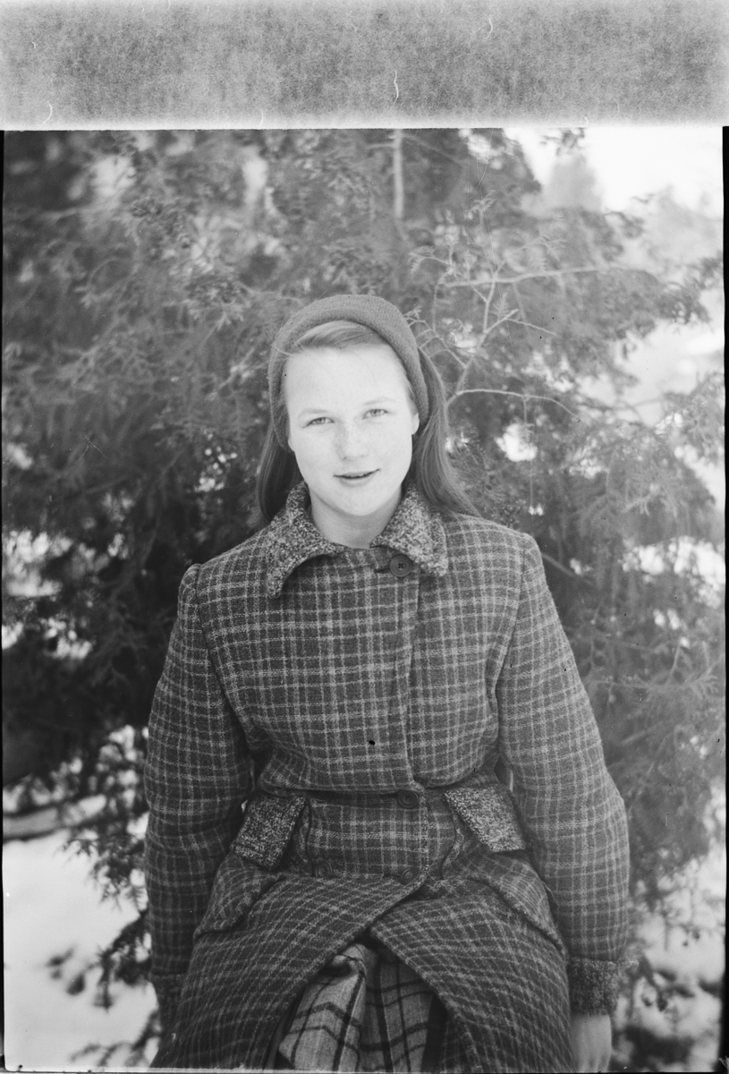 Håkon Prestkværn, Ukjent kvinne med kåpe ved et grantre.