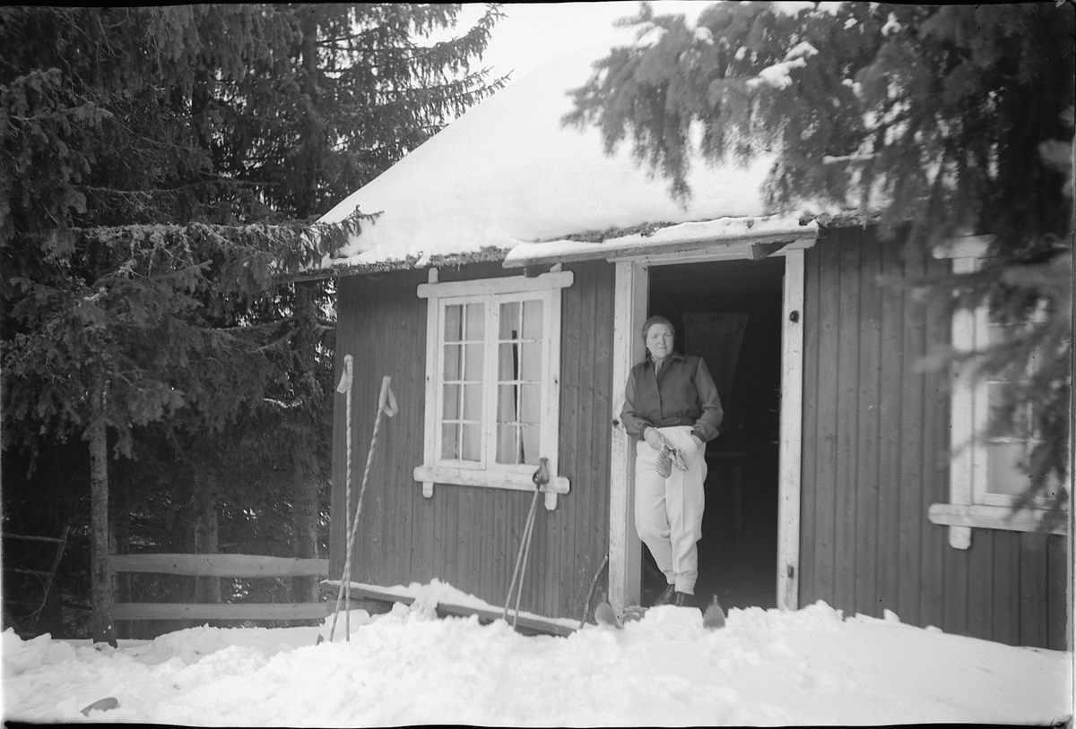 Håkon Prestkværn, Ukjent kvinne i døråpningen til ei hytte i skogen.