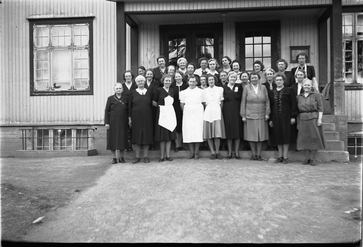 Håkon Prestkværn, Stor gruppe kvinner ved trapp til et hus.