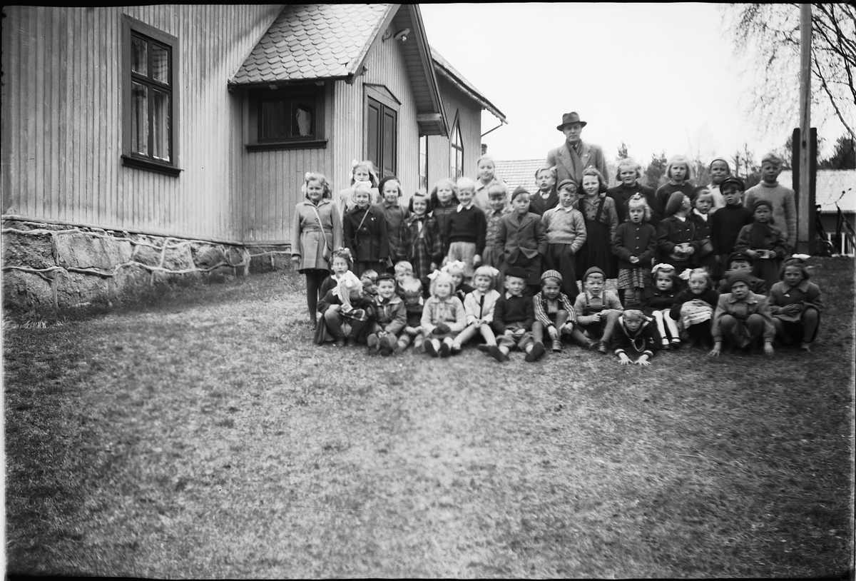 Håkon Prestkværn, Ukjent mann med stor gruppe barn foran et hus.