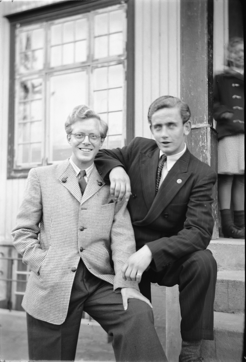 Håkon Prestkværn, To menn i dress foran ukjent bygning.