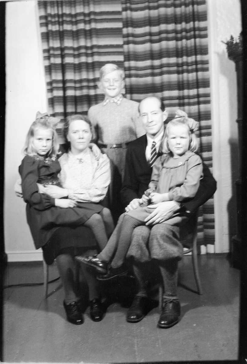 Håkon Prestkværn, Interiør, stue med ovn. Ukjent familie med tre barn.