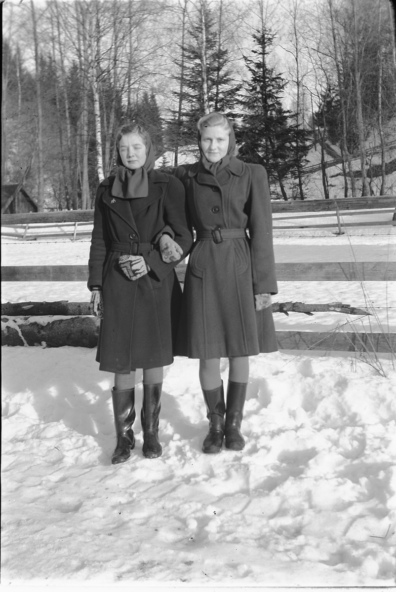Håkon Prestkværn, To kvinner med kåper, arm i arm.