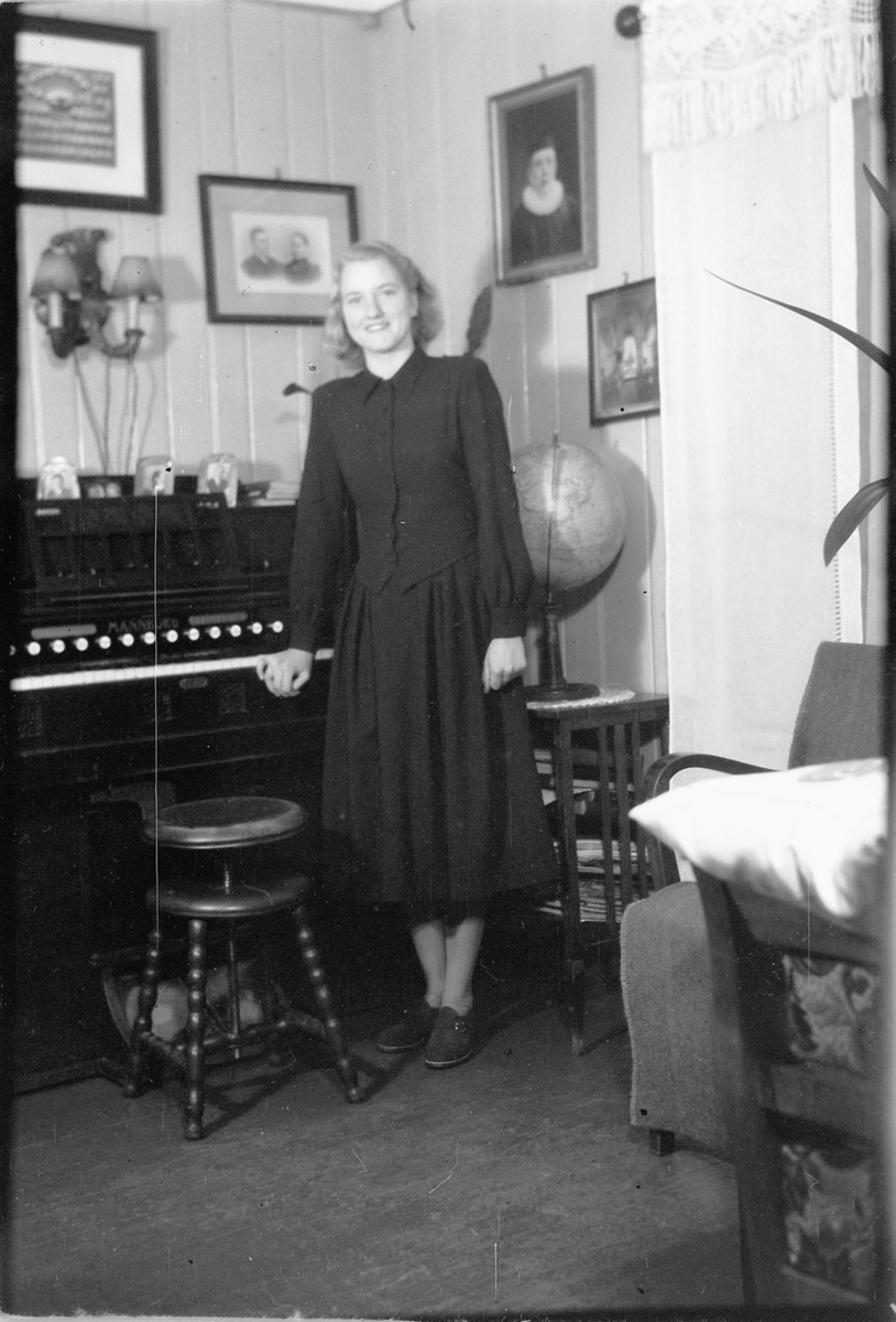Håkon Prestkværn, Interiør, stue. Bergljot Granberg, gift Roseth ved et orgel.