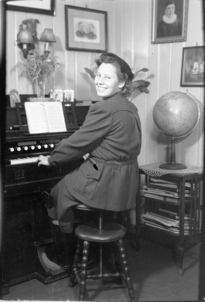 Håkon Prestkværn, Interiør, stue. Ukjent kvinne ved orgel.