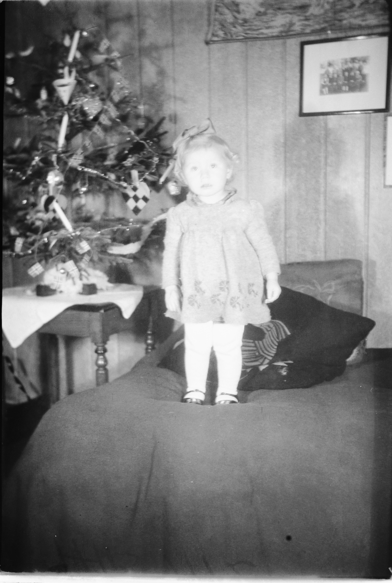 Håkon Prestkværn, Interiør, stue med juletre. Ei jente står i en sofa. "fotokonvolutt mrk. Aaseth julen 1948"