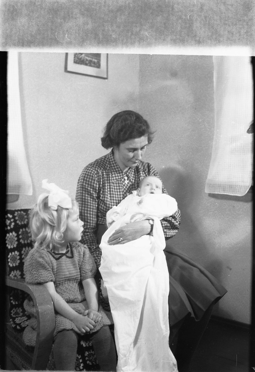 Håkon Prestkværn, Ukjent kvinne med dåpsbarnet Borgny Evensen på fanget, t.v. Edith Evensen med sløyfe i håret.