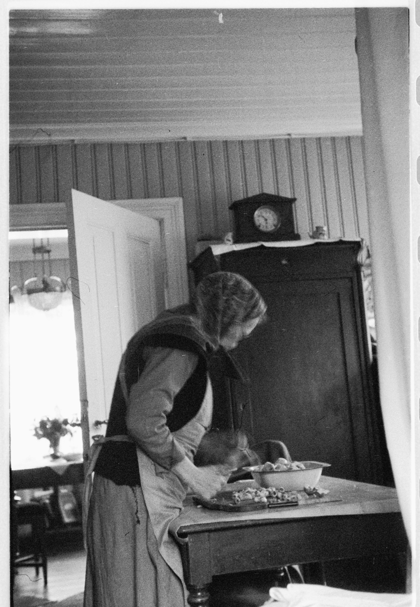Håkon Prestkværn, Interiørbilde fra Løkkekværn Gård i Moelv. Kvinne lager mat, kvinnen er Gunda Prestkværn.