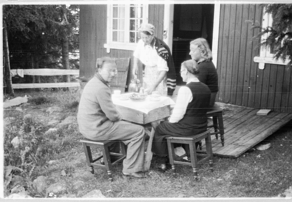 Håkon Prestkværn, Gruppe mennesker drikker kaffe på trammen til ei hytte.