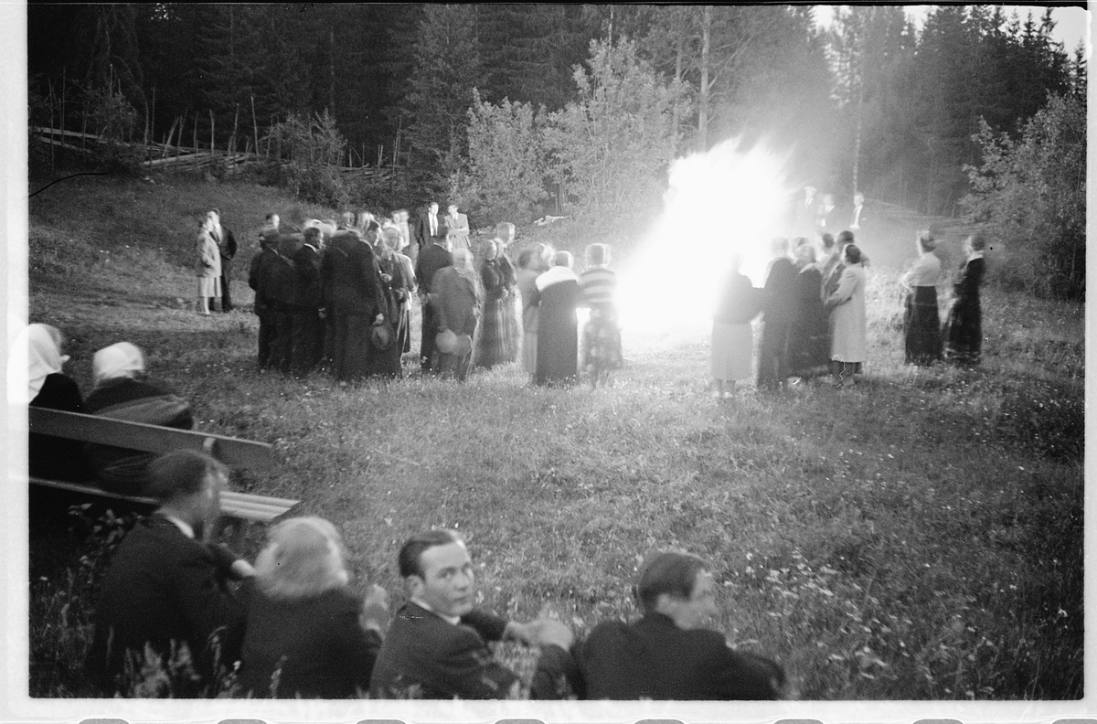 Håkon Prestkværn, Eksteriør. Gruppe mennesker samlet rundt et bål.