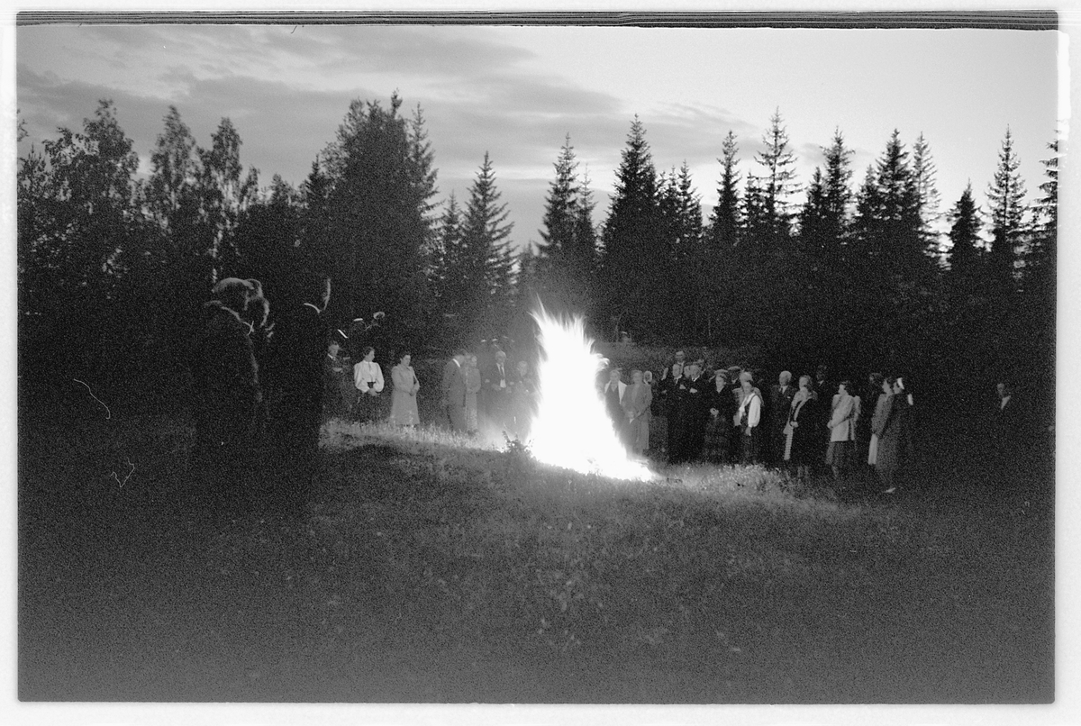 Håkon Prestkværn, Eksteriør. Gruppe mennesker samlet rundt et bål.