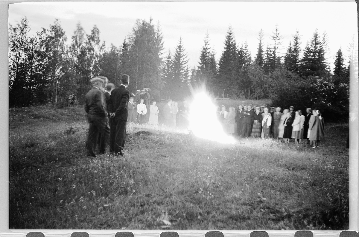 Håkon Prestkværn, Eksteriør. Gruppe mennesker samlet rundt et bål.