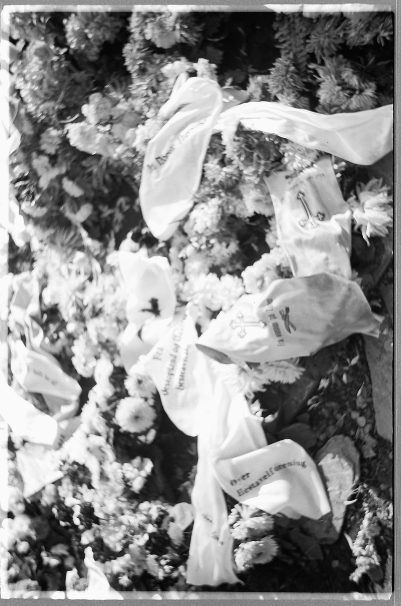 Håkon Prestkværn, En grav med blomsterkranser på en kirkegård.