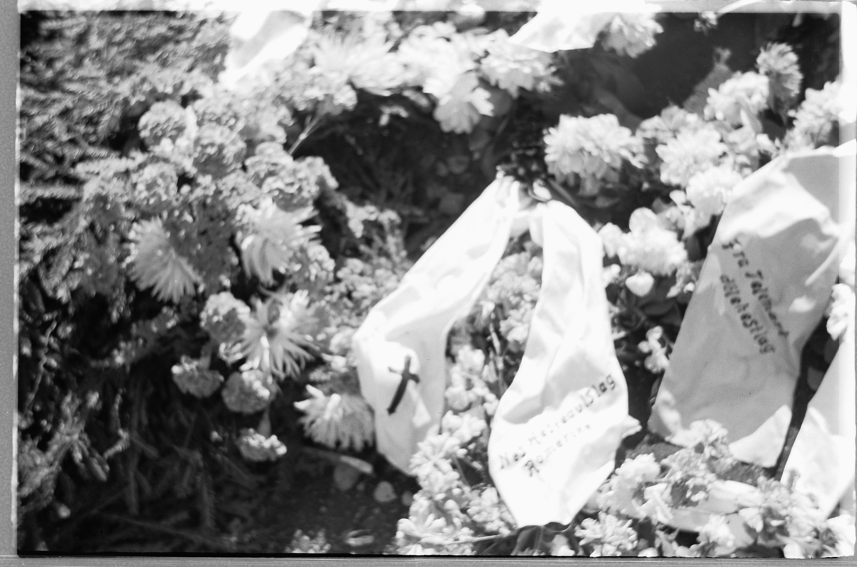 Håkon Prestkværn, En grav med blomsterkranser på en kirkegård.