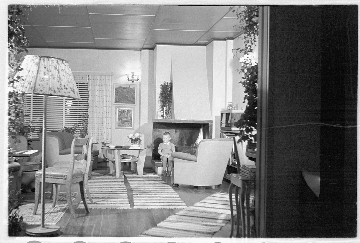 Håkon Prestkværn, Interiør, stue med sofa, stålampe og peis.