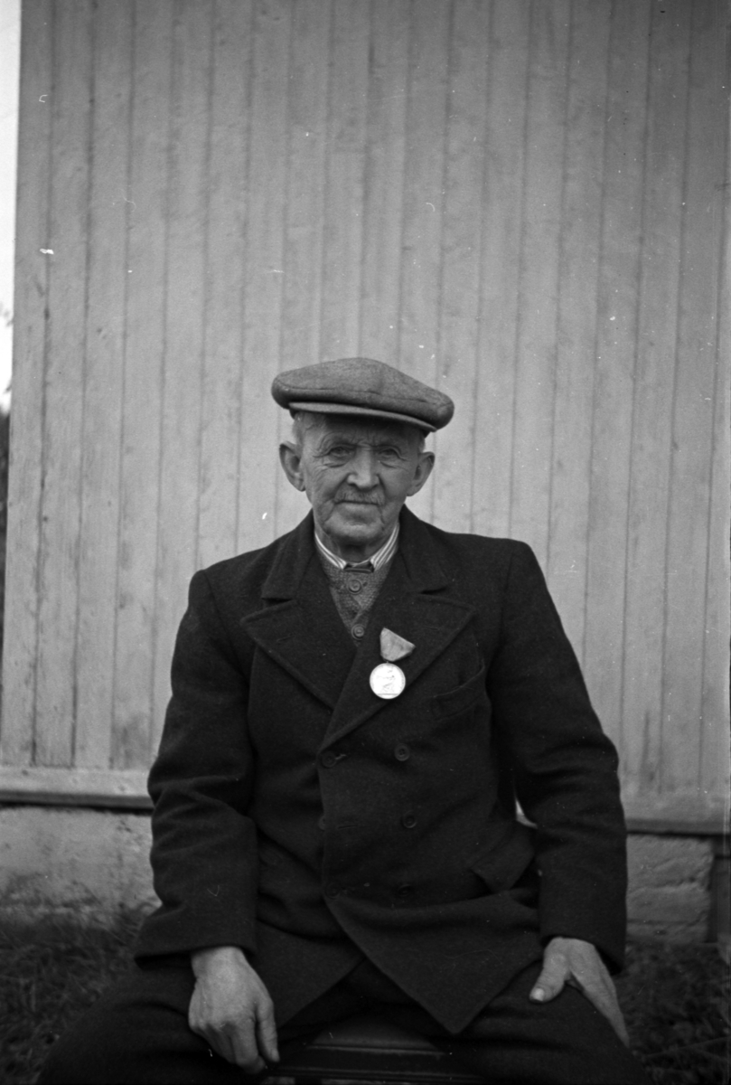 Håkon Prestkværn, Eldre mann med medalje på kragen.