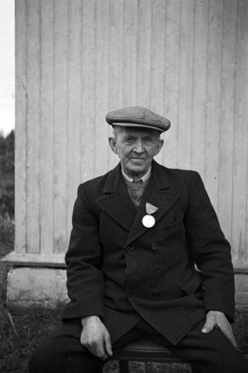 Håkon Prestkværn, Eldre mann med medalje på kragen.