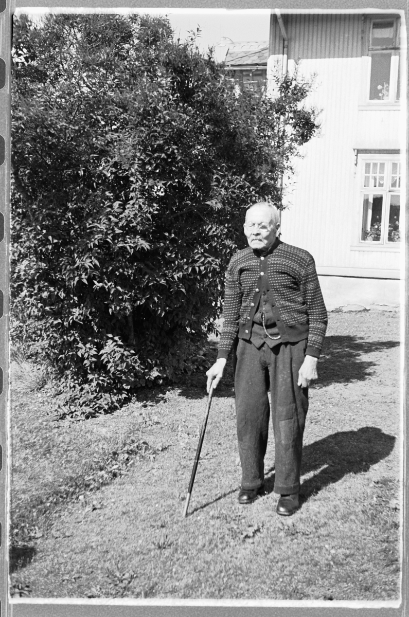 Håkon Prestkværn, Eksteriør, hage. Eldre mann med stokk.