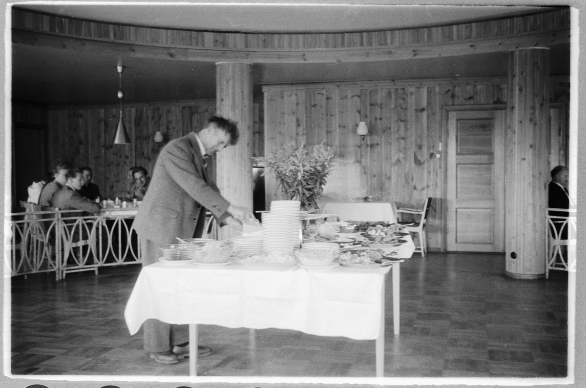 Håkon Prestkværn, Ukjent mann forsyner seg av buffè, på Dalseter Høyfjellshotell i Sør-Fron, Oppland. Bildet må være tatt mellom 1950 (nybygd fjellstue) og 1963 når det brant.