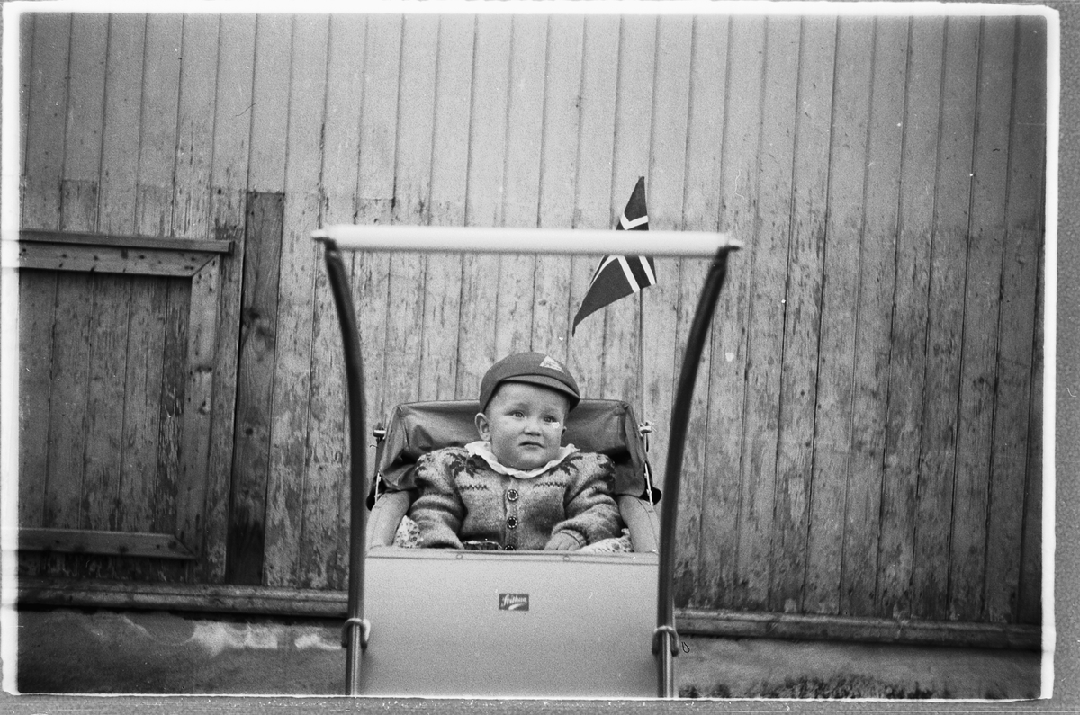 Håkon Prestkværn, Liten gutt i en barnevogn med det norske flagg.