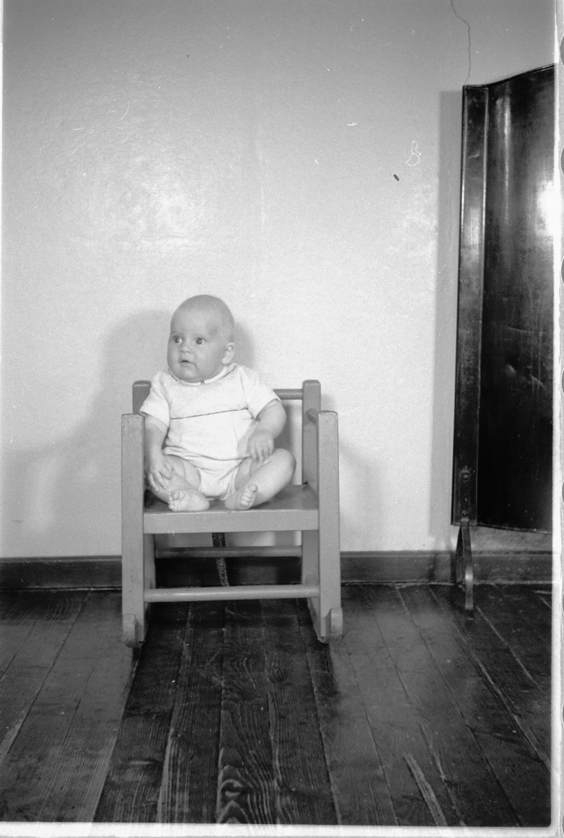 Håkon Prestkværn, En baby sitter i en stol.