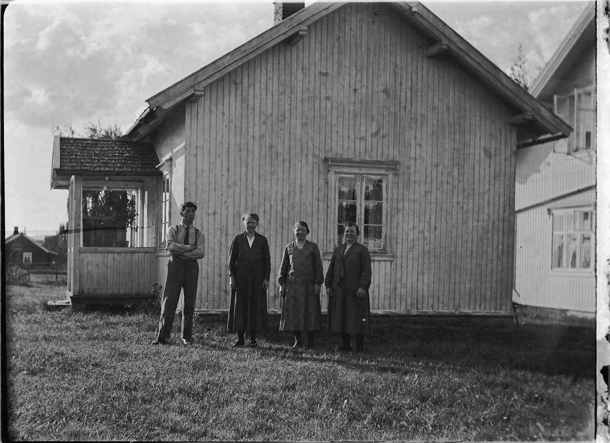 Ole M Martinsen, En mann og tre kvinner foran et hus.