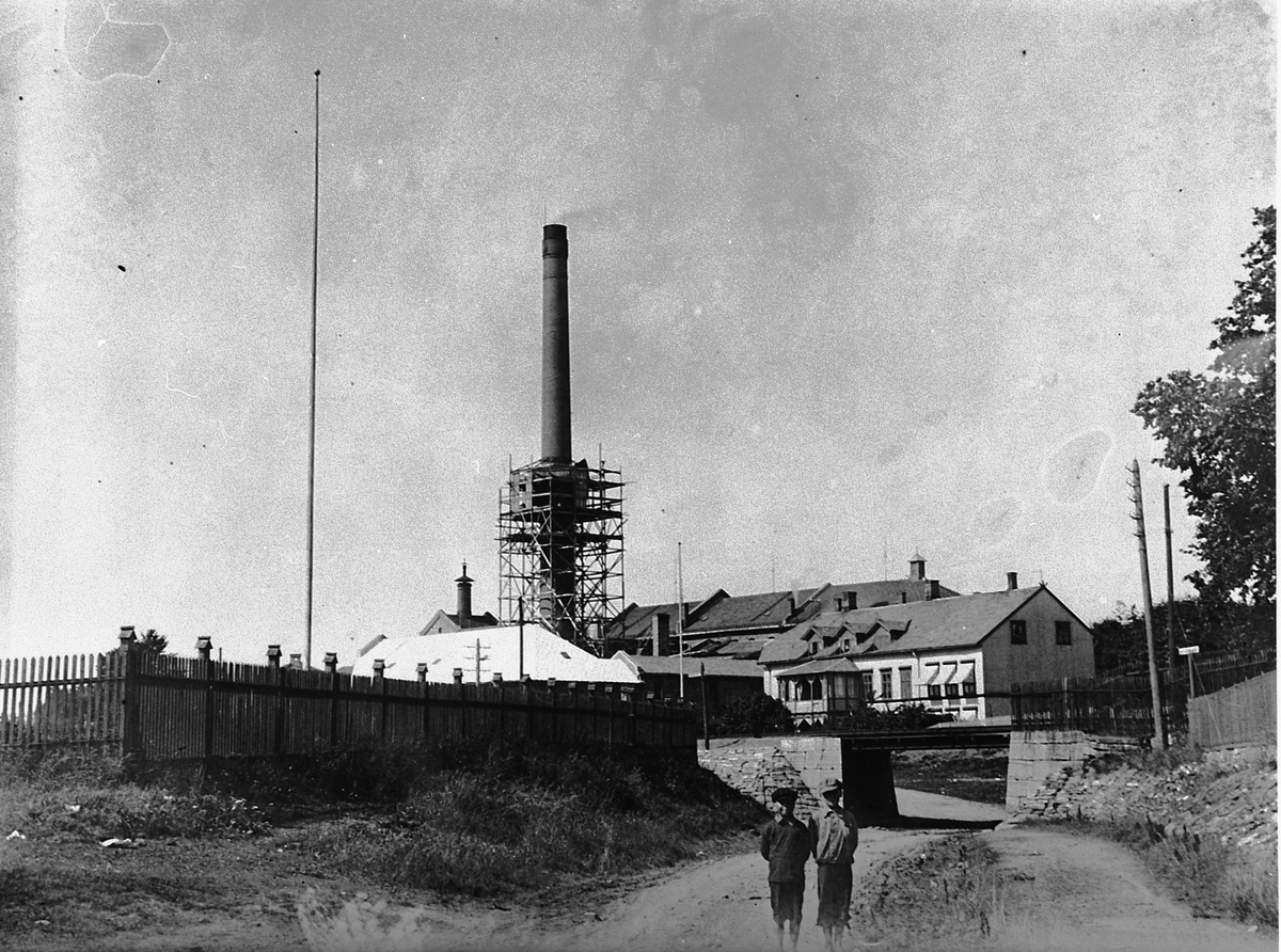 Hans Emil Erichsen, Melkefabrikken på Hamar. Bestyrerboligen. 2 gutter ved jernbaneundergangen i Skappelsgate. Melkefabrikken begynt sin virksomhet i 1875 og ble ombygget i 1892 og 1914.