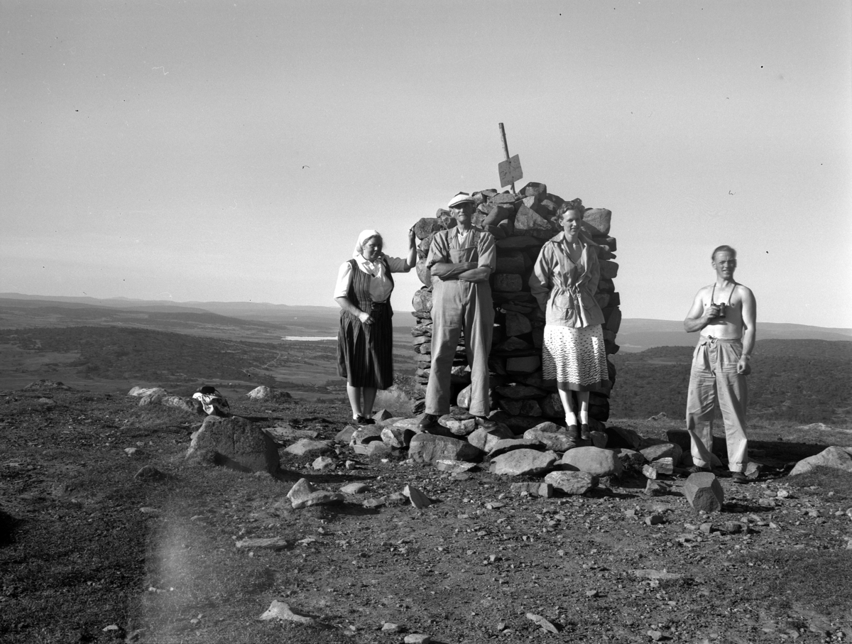 Kristian Heramb, To kvinner og to menn ved en varde på fjellet.