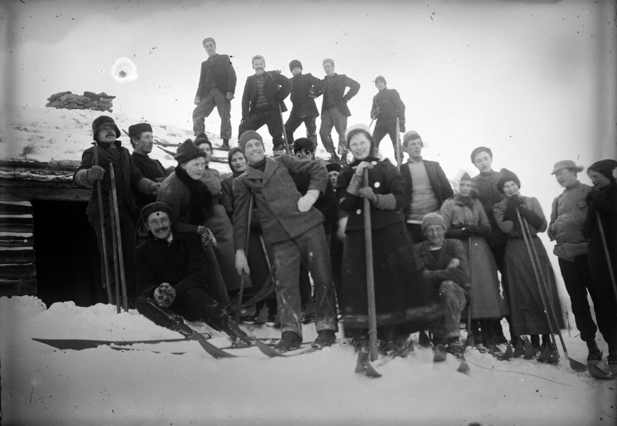 Johannes Larsen Alhaug, Stor gruppe på ski utenfor ei hytte.