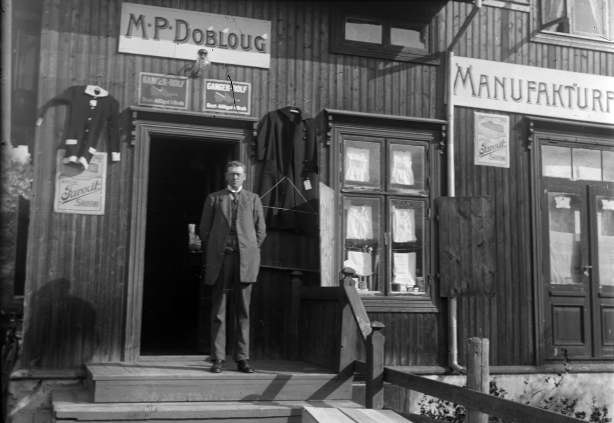Mikkel Sveinhaug, M. P. DOBLOUG, MANUFAKTURFORRETNING I MOELV. MIKKEL P. DOBLOUG PÅ TRAPPA FORAN SIN FØRSTE BUTIKK I MOELV. BILDE ER I FRA FØR 1915.