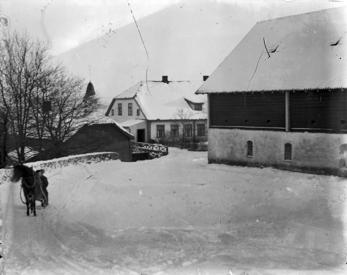 Martin Finborud, To menn på hest og slede. Grefsheim gård, Nes, Hedmark. Låve og hovedbygning.