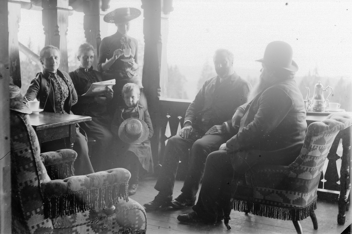 Hans Emil Erichsen, Gruppe ukjente voksne og barn på veranda.