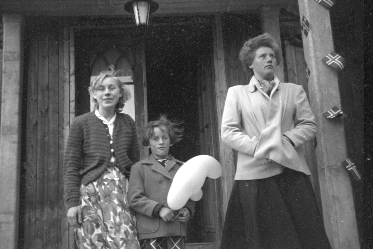 Håkon Prestkværn, .Gruppe, 17. mai. Barn med ballong. Norske flagg. Kathrine Bjørge, Moelv, flankert av døtrene til Even Framdahl, Torborg og Magnhild Framdahl.