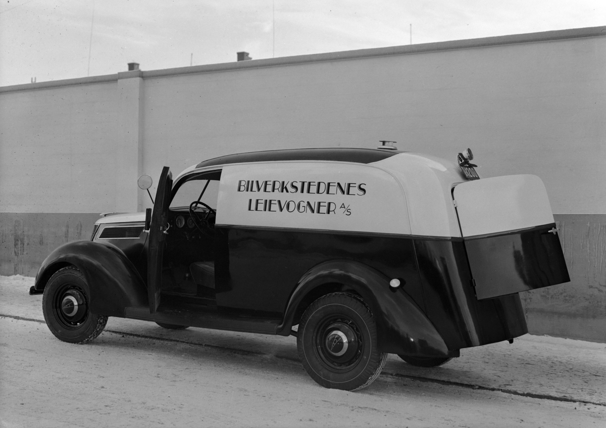 Normann Fotoatelier, Oplandske Auto, Hamar. Varebil. Bilverkstedenes leievogn no. 4. D-1200. Ford V8 1937 med norskbygd karosseri. Reg. nr. D-1200 er et prøvenummer (den røde bunnfarven fremtrer som sort på foto).
